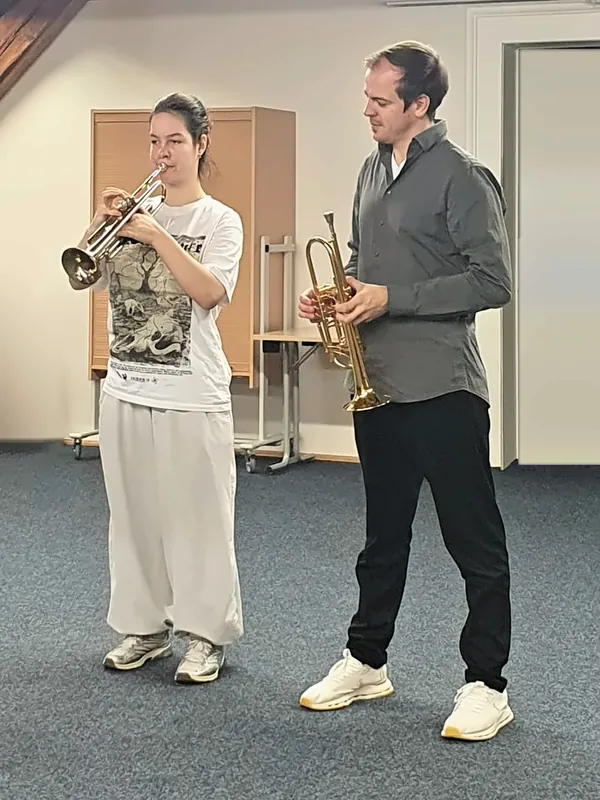 Eine Schülerin spielt Trompete, Oles Burak hört ihr zu